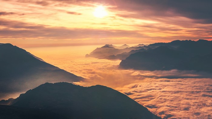 Mountains above clouds at sunset