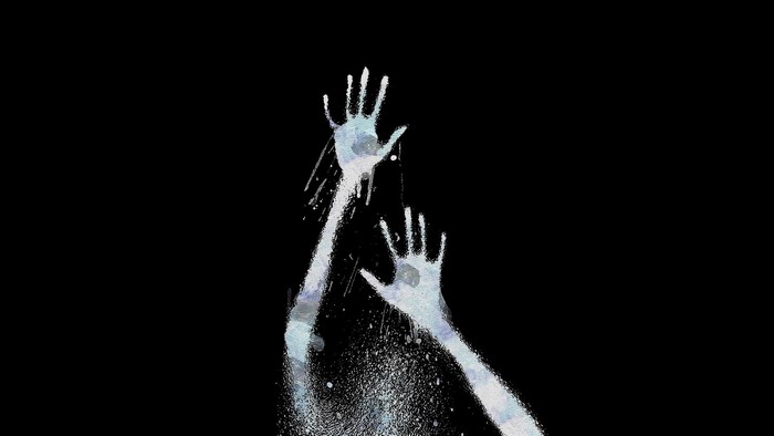 Hands pressed against glass on black background