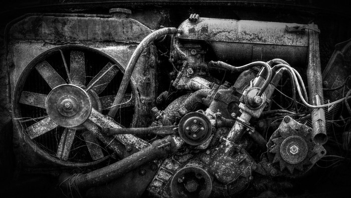 Monochrome image of a rusty Skoda car engine with fan