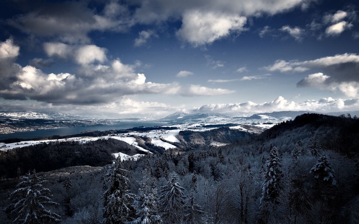 Snowy mountains and lake under cloudy sky