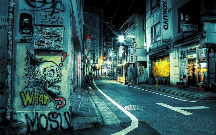 Graffiti-covered street in a Japanese city at night