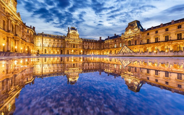 Louvre Museum courtyard at dusk with reflection