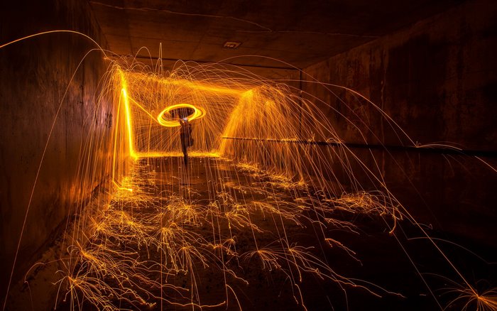 Person creating light painting with sparks in tunnel