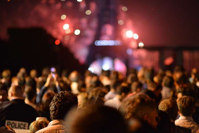 Crowd watching fireworks near Eiffel Tower at night