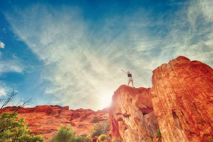Woman on Red Rocks Under Blue Sky 4K