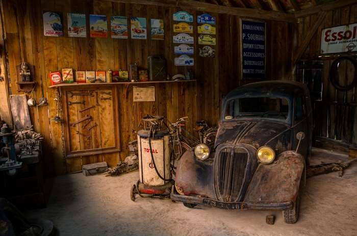 Old car in a rustic garage with vintage items