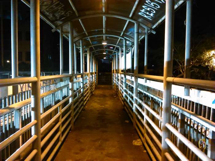 Overpass walkway at night with graffiti