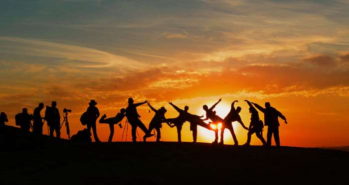 Group of people silhouetted against a sunset
