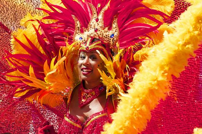 Woman in colorful carnival costume with feathers and crown