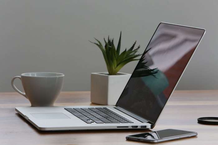MacBook Pro with coffee cup and smartphone on desk