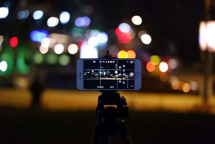 Smartphone on tripod recording city lights at night