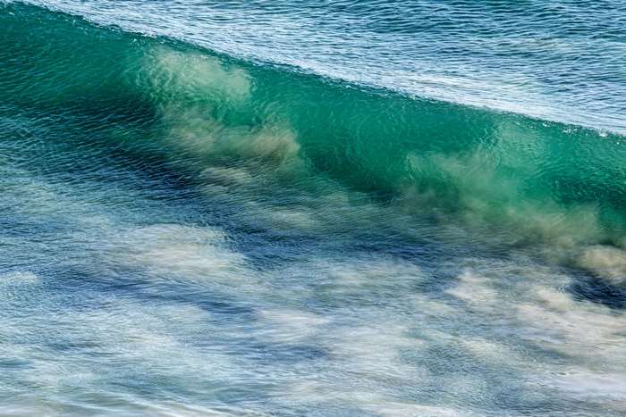 Turquoise ocean wave with white foam