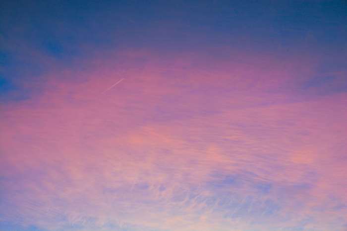 Pink and blue sky with contrail at sunset 4K