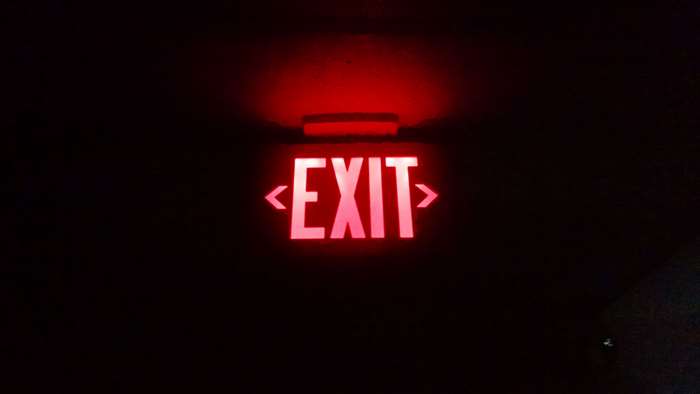 Red EXIT sign in the dark 4K