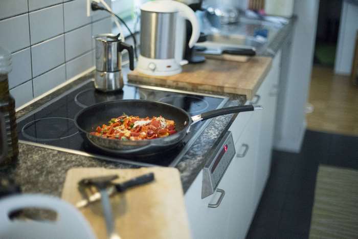 Food cooking in a pan on a stove in a kitchen