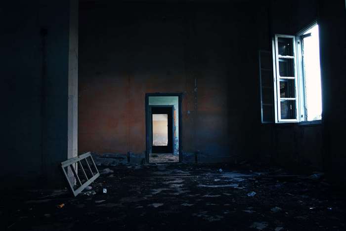 Abandoned room with broken window and doorways