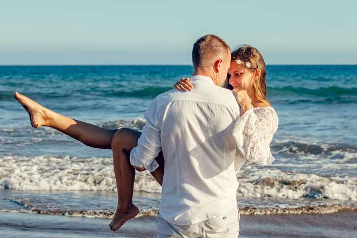 Couple embracing on a beach with ocean waves