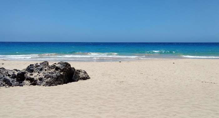 Beach with volcano rock and blue ocean