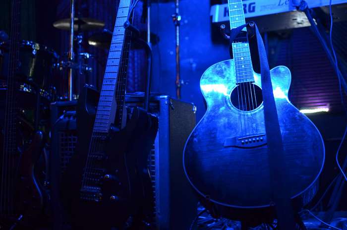 Electric and acoustic guitars on stage with drums and keyboard