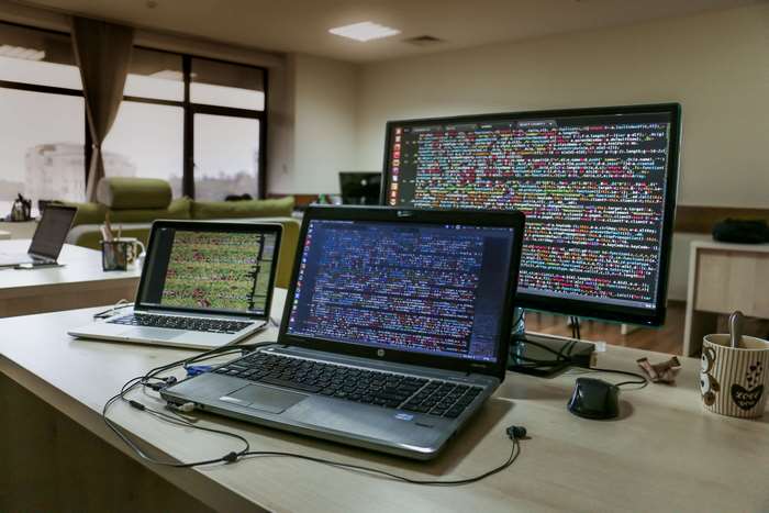 Computers and monitors displaying code in an office