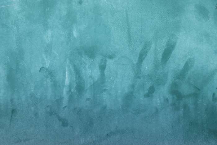 Aqua blue textured surface with smudges and handprints