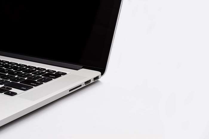 Close-up of a silver MacBook laptop with a black screen and keyboard