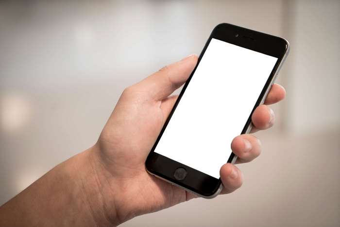 Hand holding an iPhone 6 with a blank screen
