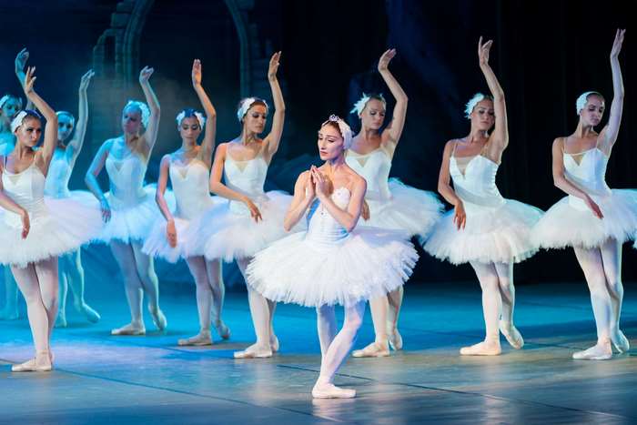 Ballet dancers in white tutus performing on stage