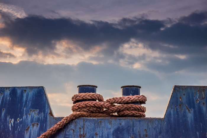Rope tied to bollards on a blue metal structure