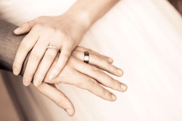 Couple's hands with wedding rings