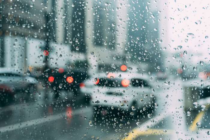 Raindrops on a window overlooking city traffic