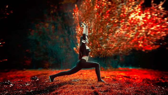 Woman doing yoga in a park during fall
