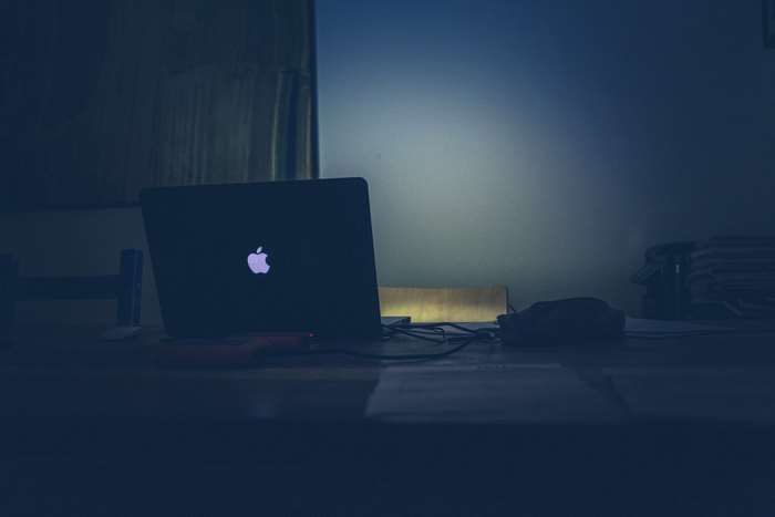 MacBook laptop on a dark desk