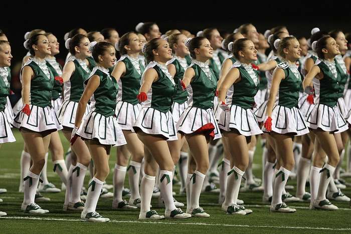 Cheerleaders in uniform performing on a field