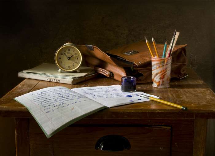 Vintage desk with school supplies and alarm clock