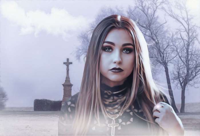 Gothic young woman in a cemetery with a cross