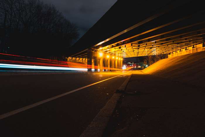Light trails under a bridge at night