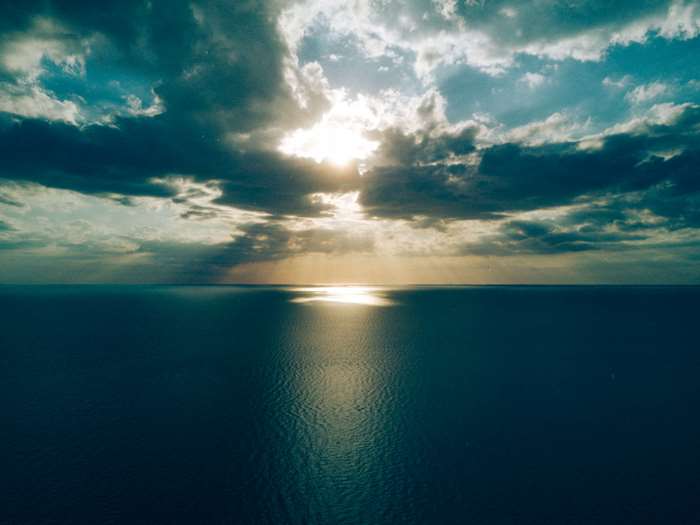 Sunlight breaking through clouds over the ocean