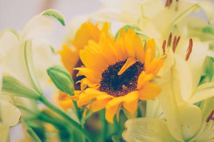 Yellow sunflower and lilies in a bouquet
