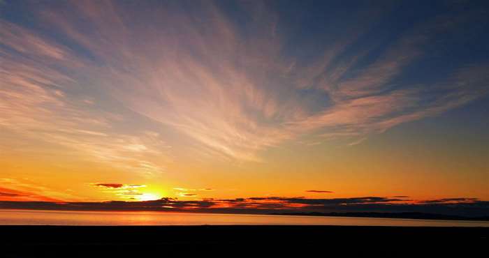 Sunrise over the ocean with wispy clouds