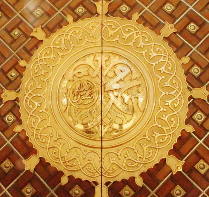 Golden Islamic calligraphy on wooden doors in Saudi Arabia