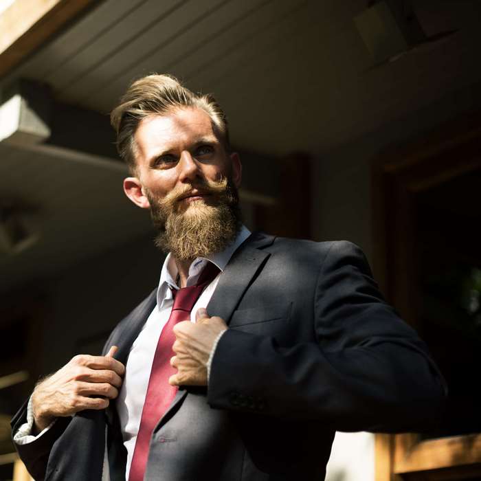 Man in suit with beard and red tie