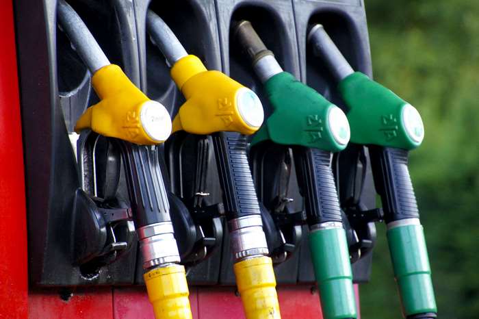 Gas pumps with yellow and green nozzles at a gas station