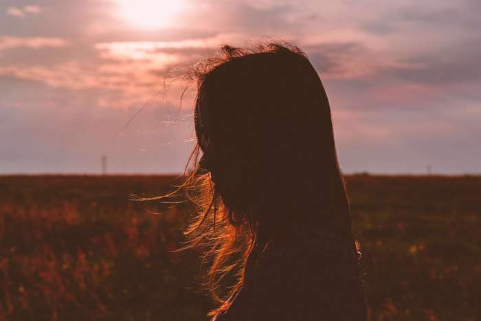 Silhouette of a girl at sunset in a field 4K