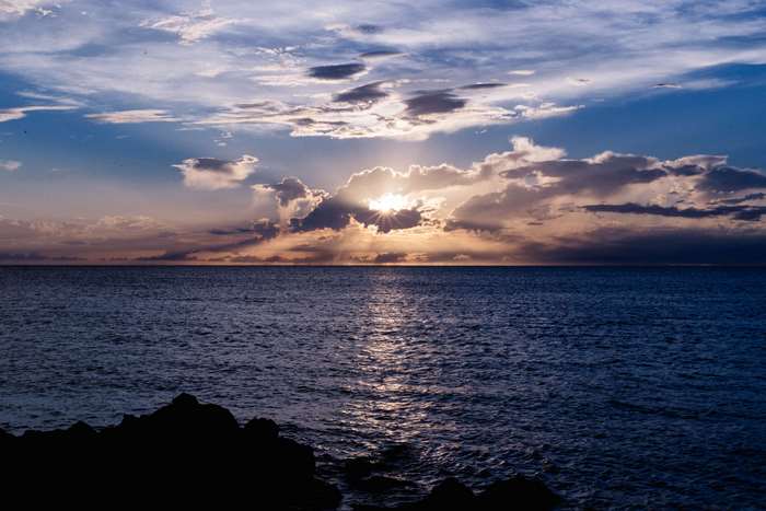 Sunset over the ocean with dramatic clouds
