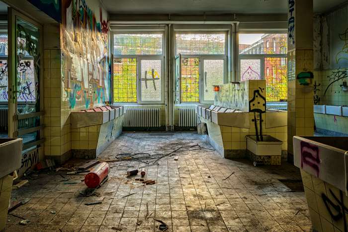 Abandoned building interior with graffiti and broken tiles