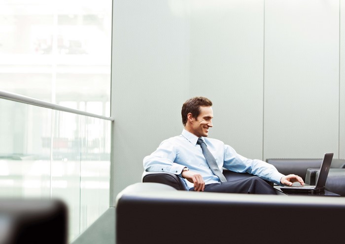 Smiling businessman working on a laptop in an office