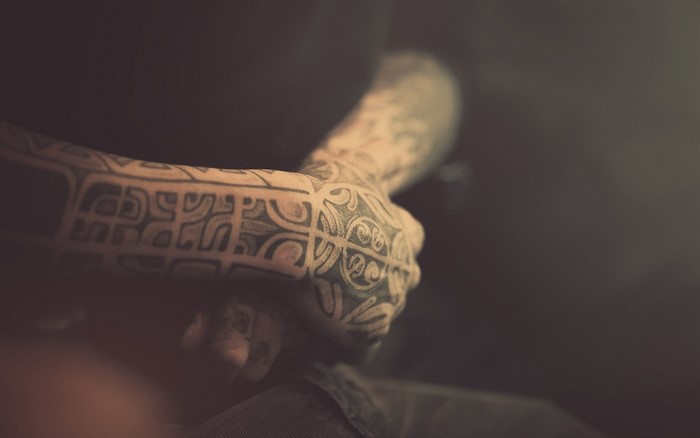 Man's arm and hand with tattoos