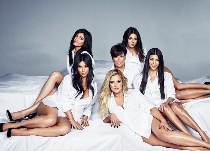 The Kardashian-Jenner sisters and Kris Jenner on a bed