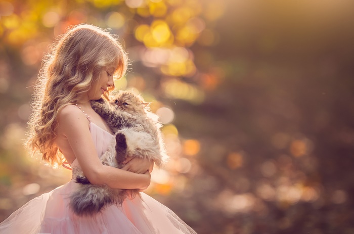Girl holding a fluffy cat outdoors